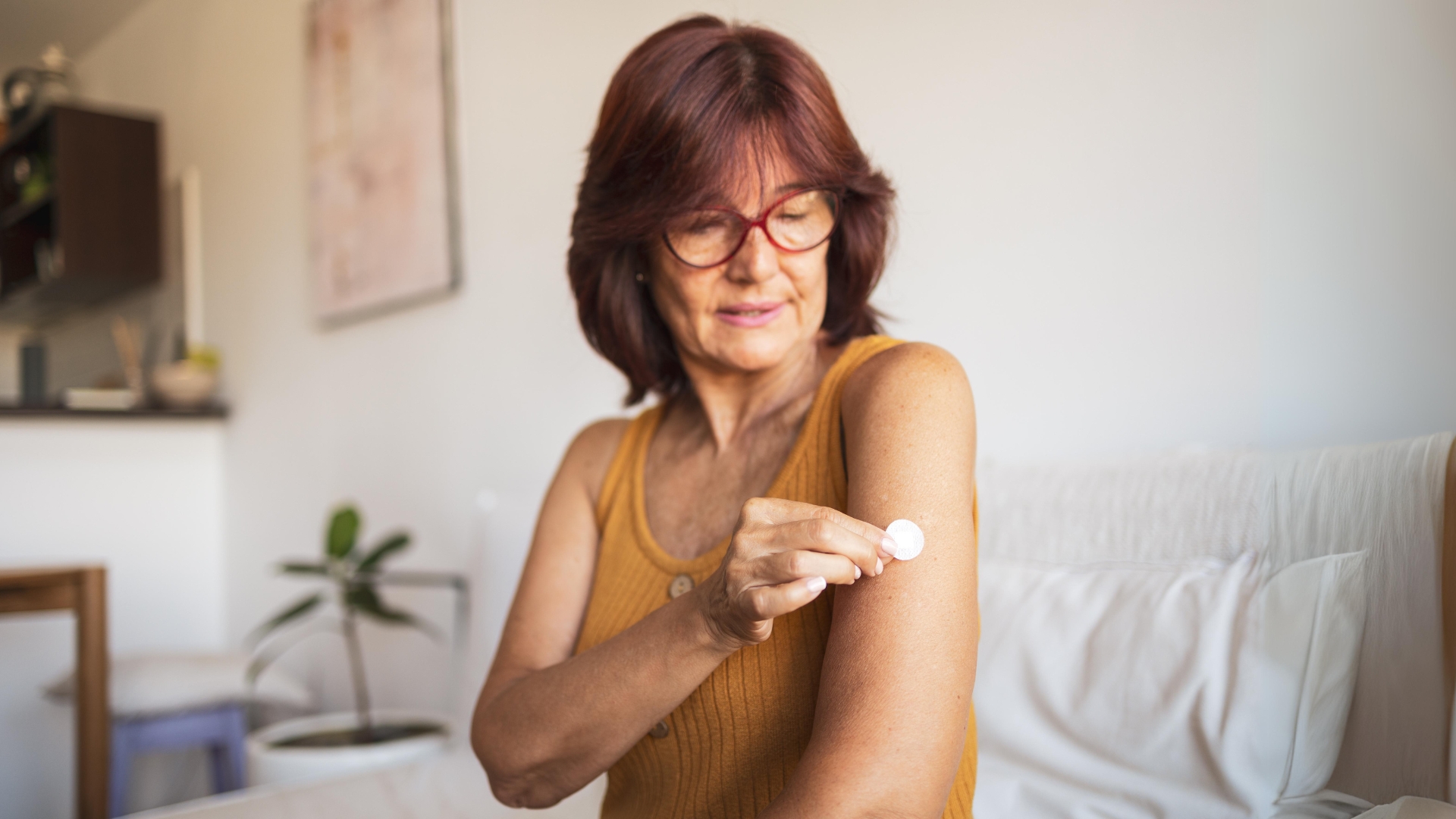 A woman in her early 60's applying hormone replacement therapy into her left arm