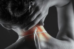 Person experiencing neck pain while exploring IV ketamine therapy for chronic pain