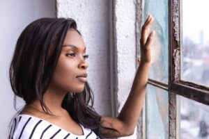 Woman looking out a window while considering IV ketamine therapy for depression